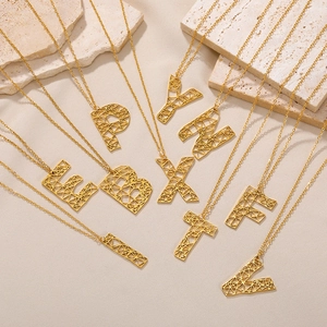 Detail van de gouden holle geometrische letterhangers met glanzende metaaltextuur