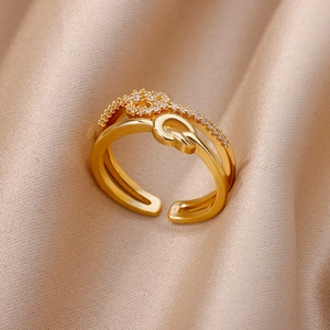 Close-up of golden double-layer knot ring with micro-set zircons on silk background