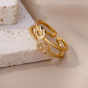 Detail of gold double-layer geometric ring with knots and zircon stones on silk