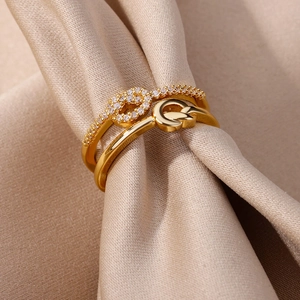 Macro view of a gold double-layer concentric knot ring with zircon pavé on champagne silk