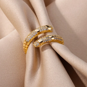 Macro shot of gold geometric layered ring with sparkling pavé zircons on silk fabric