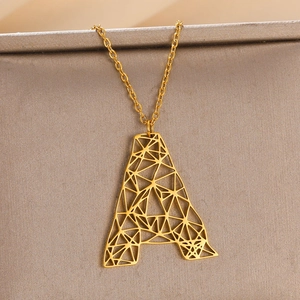 Macro-opname van goudkleurige holle letter A-hanger met geometrisch minimalistisch design