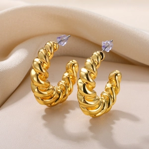Macro shot of gold twisted croissant hoop earrings with glossy polished finish and backing