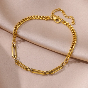 Detail of gold Figaro and paperclip link chain with lobster clasp on satin fabric
