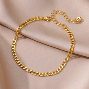 Close-up of gold Figaro blade chain with lobster clasp on beige silk background
