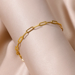 Macro detail of 18k gold plated stainless steel paperclip link chain on silk