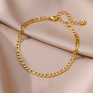 Detail of gold Figaro ankle bracelet with lobster clasp and extension chain on silk