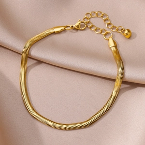 Flat gold snake chain anklet with lobster clasp and heart charm on silk background