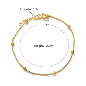 Detail of 18K gold plated bead anklet featuring a snake chain and five polished golden beads
