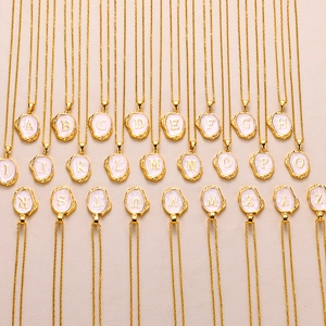 Detail showing 26 initial pendants with gold relief on pink enamel and 18K plated chains