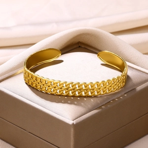 Close-up of gold double-layer woven chain cuff bracelet in a satin jewelry box