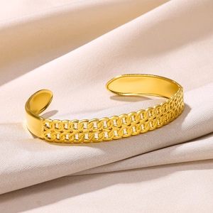 Detailed shot of gold-plated stainless steel open cuff bracelet with hollow Cuban link texture