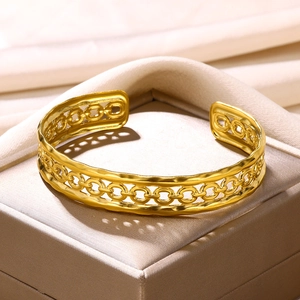Macro detail of gold-plated stainless steel hollow chain link cuff bracelet texture