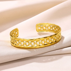Detailed close-up of a gold-plated stainless steel open cuff with hollow ring patterns