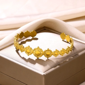 Macro detail of gold-plated bangle with sunburst sun pattern in elegant jewelry gift box