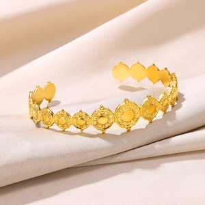 Detailed view of golden boho cuff bracelet featuring embossed sunburst round medallions