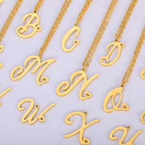 Colliers dorés avec pendentif cœur ajouré et lettre A-Z sur fond texturé mauve
