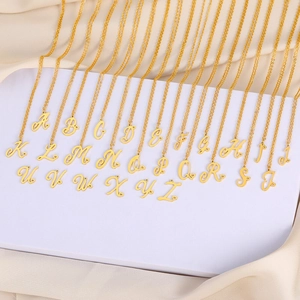 Vue détaillée des pendentifs alphabet A-Z dorés avec petits détails de cœur ajouré