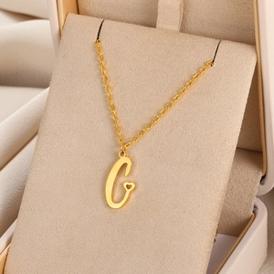 Vue détaillée du collier pendentif lettre G dorée avec petit cœur sur boîte à bijoux
