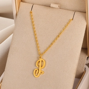 Collier doré avec pendentif lettre P cursive et détail cœur dans un coffret