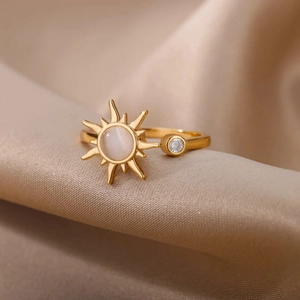 Detail of a rotating sunflower ring featuring a white opal center on silk fabric