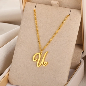 Détail du pendentif lettre U doré avec un petit cœur sur une fine chaîne et coffret cadeau