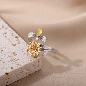 Macro detail of rotating sunflower and bee ring with yellow zircon on stone