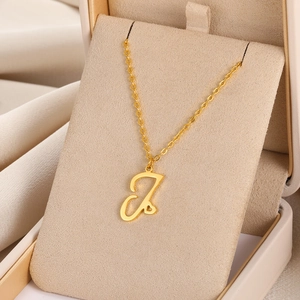 Gros plan du pendentif lettre I doré avec cœur sur une boîte à bijoux en velours