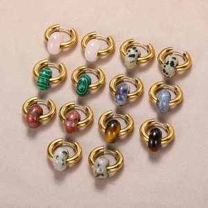 Bohemian gold hoop earrings set with assorted natural stone donut charms on beige fabric
