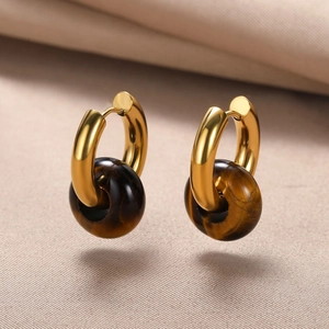Detail shot of vintage golden hoop earrings with brown natural stone donut charms