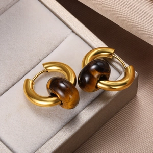 Close-up of vintage golden hoop earrings featuring natural tiger eye stone beads