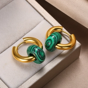 Close-up of vintage gold hoop earrings with green malachite beads on silk