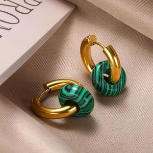Detailed shot of gold hoop earrings with green malachite-style textured stone pendants