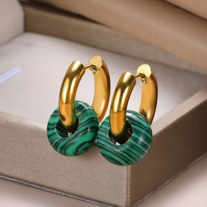 Macro view of gold hoop earrings with green striped malachite doughnut pendants