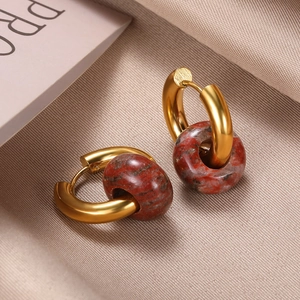 Detail of vintage gold hoop earrings featuring reddish-brown marbled natural stone beads