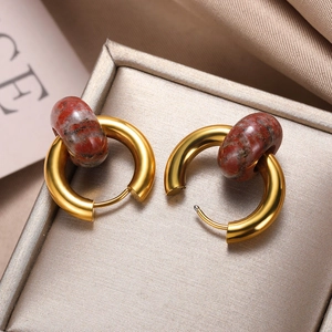 Detail of gold donut earrings with reddish-brown marble beads on champagne silk