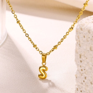 Detailed view of 18K gold plated 3D bubble letter S pendant on dainty beaded chain