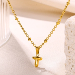 Close-up of 18K gold plated letter T bubble pendant with beaded ball chain design