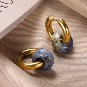 Macro view of gold hoop earrings with polished finish and blue natural stone beads