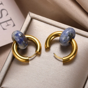 Detail shot of vintage gold hoops with blue natural stone donut pendants on satin