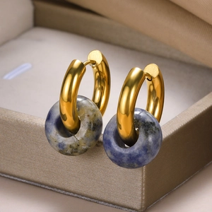 Detailed macro view of vintage gold textured hoops with natural blue stone donuts