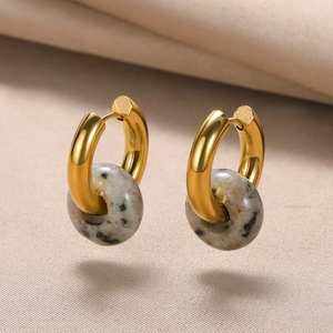 Macro detail of French retro donut earrings with natural jasper stone and gold finish