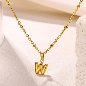 Detailed close-up of a gold 18K plated bubble letter W pendant on a delicate beaded chain