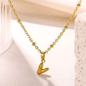Macro shot of 18K gold plated letter V bubble pendant with delicate beaded chain detail