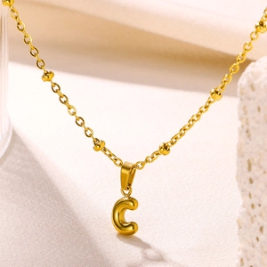 Detailed close-up of 18K gold-plated bubble letter C pendant with beaded link chain necklace