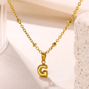 Close-up of a 18K gold-plated bubble letter G pendant with minimalist bead chain