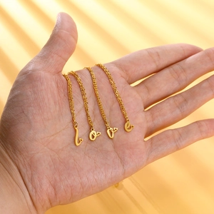 Collana in acciaio dorato con ciondoli a lettere LOVE e piccoli cuori decorativi