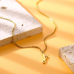 Dettaglio di una catena d'oro in acciaio con ciondolo lettera J e piccolo cuore