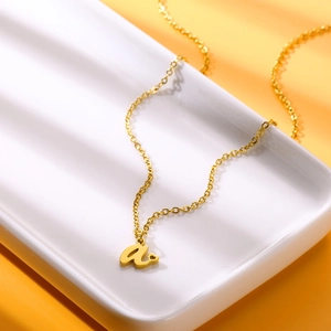 Dettaglio ravvicinato di una collana dorata in acciaio inox con lettera a e piccolo cuore