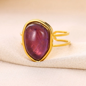 Macro detail of teardrop purple gemstone set in an 18K gold plated stainless steel ring